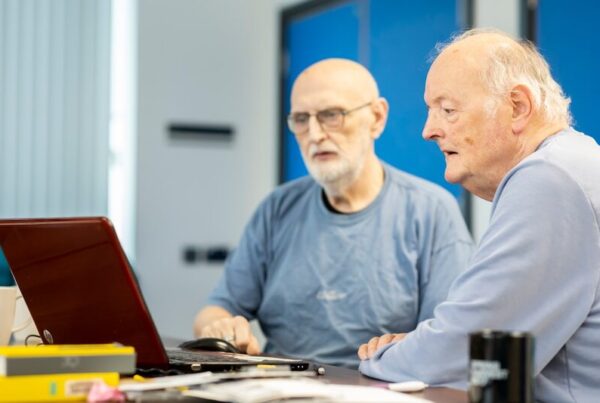 Two colleagues collaborating and sharing knowledge at a laptop