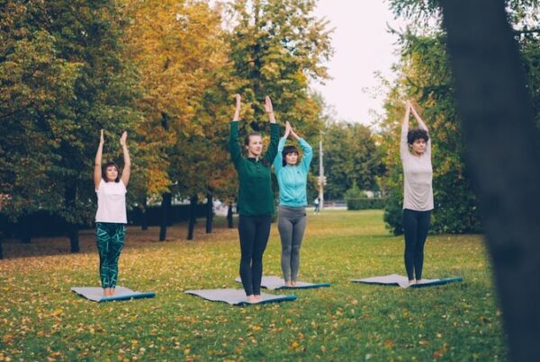 People practising yoga outdoors in a park setting