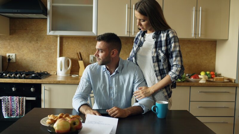 Older couple reviewing financial documents together at kitchen table