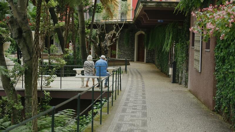Older couple sitting together on a bench in a garden