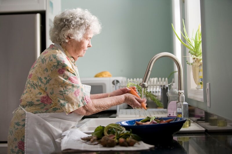 Older adult washing fresh vegetables for healthy cooking