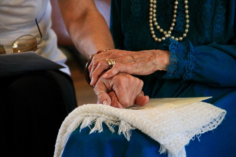Family member holding the hand of an older adult — understanding delirium