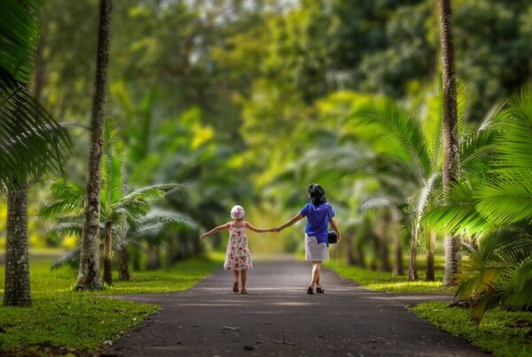 Grandparent and grandchild walking together in a park