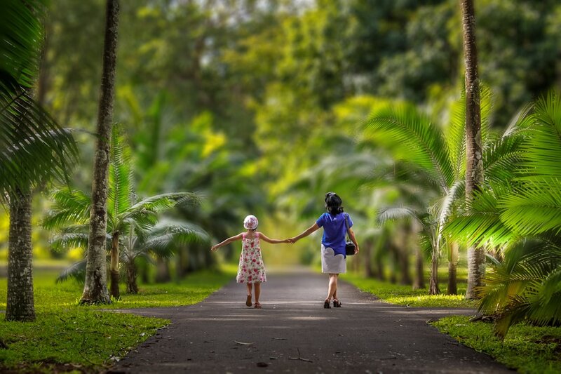 Grandparent and grandchild walking together in a park