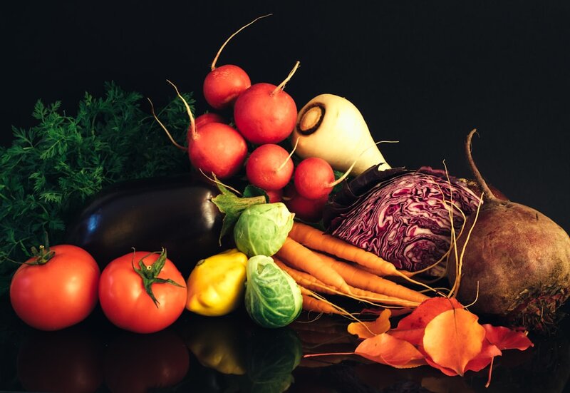 A colourful selection of fresh vegetables and whole foods on a kitchen counter