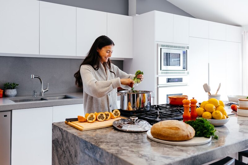 Woman smiling while preparing fresh vegetables in a kitchen