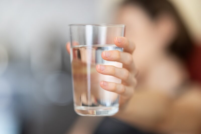A glass of water being poured, representing hydration as the key prevention step for kidney stones