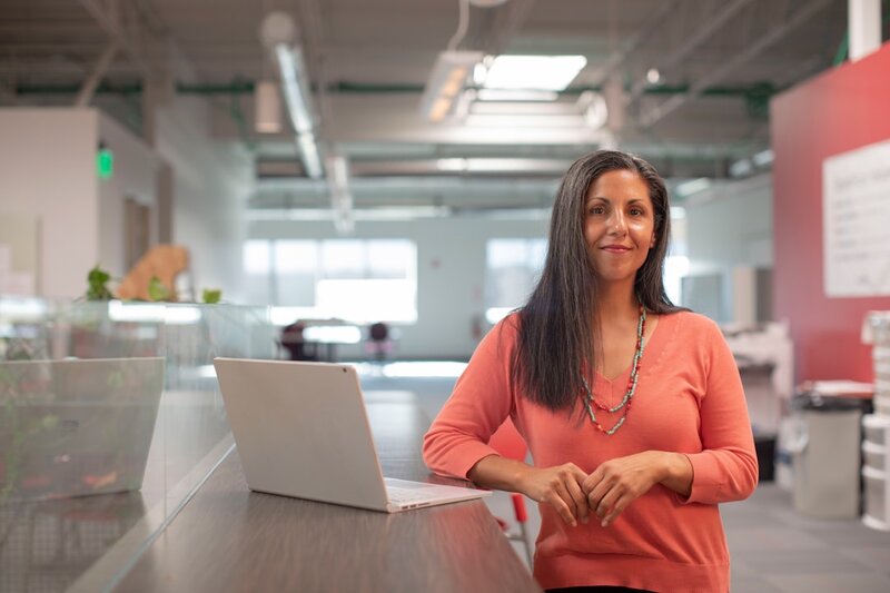 Woman in her fifties working at a laptop in a bright office