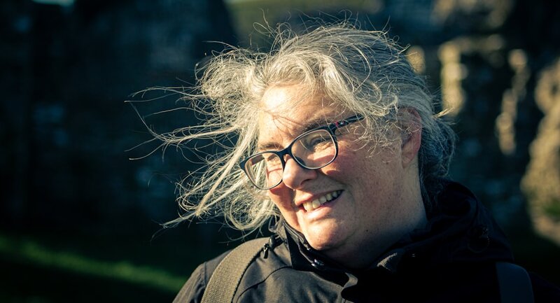 Older woman with glasses smiling outdoors